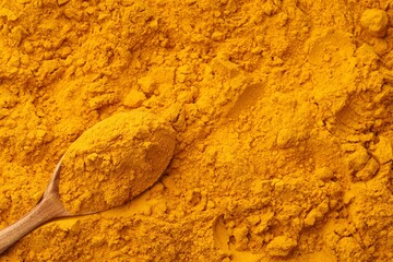 Turmeric powder in spoon on spice, closeup. Space for text