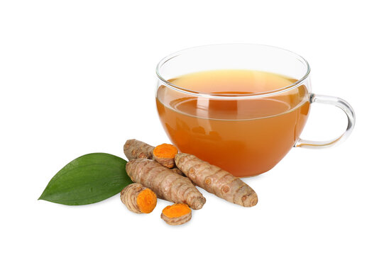 Aromatic turmeric tea in glass cup, roots and green leaf isolated on white