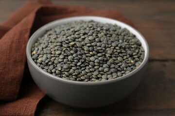 Raw green lentils on wooden table, closeup