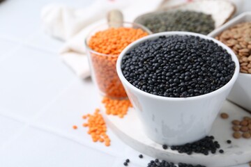 Different types of lentils on white table, closeup