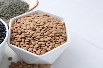 Different types of lentils on white table, closeup
