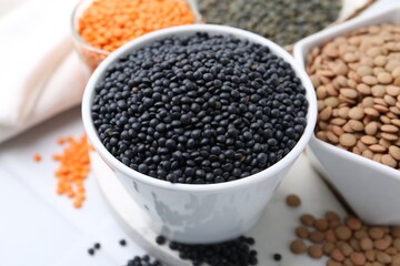 Different types of lentils on white table, closeup