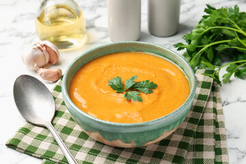 Delicious lentil cream soup with parsley served on white marble table