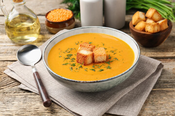 Delicious lentil cream soup served on wooden table