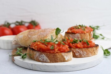 Tasty bread with tomatoes and parsley on light table, closeup