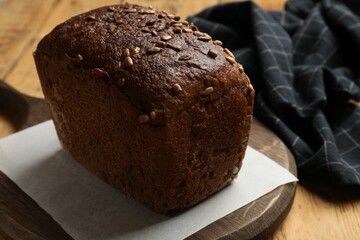 Fresh loaf of bread on wooden table, closeup