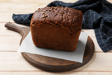 Fresh loaf of bread on wooden table, closeup