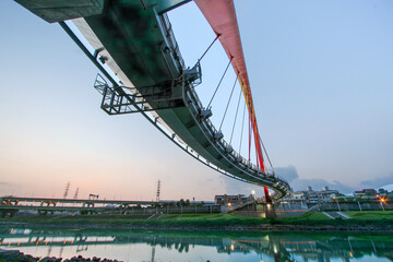 A view of Taipei's Rainbow Bridge at twilight, a pedestrian-only bridge spanning the Keelung River in Taiwan.
