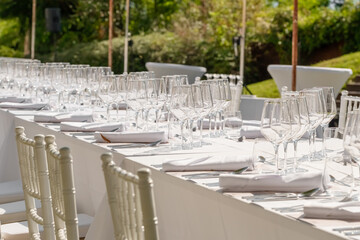 Served wedding table with plates, white chairs, napkins and wine glasses