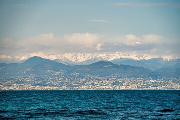 Alps mountains with white snow and clouds, sea in Nice, France