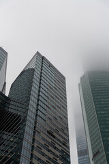 Obraz premium Skyscrapers enveloped in fog showcasing urban architecture and misty atmosphere