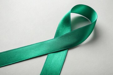 Close up photo of a green ribbon with plain color background