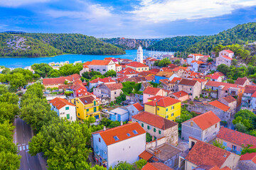 Stunning drone image of old charming town of Skradin, Croatia, featuring nautical boats, colorful traditional architecture, and the serene waters of the Krka River and Adriatic Sea