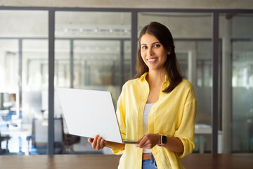 Smiling latin hispanic female manager, professional specialist working, browsing at laptop computer...