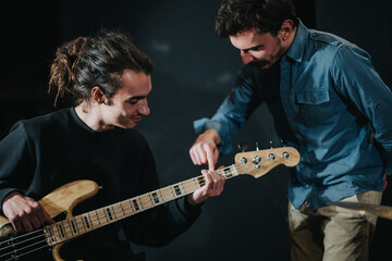 A musician instructing a student on playing bass guitar, emphasizing technique and coordination....
