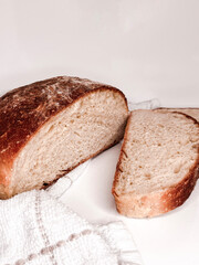 Freshly baked round bread cut into slices on a white background. Close up.