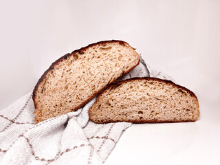 Freshly baked round bread cut into slices on a white background. Close up.