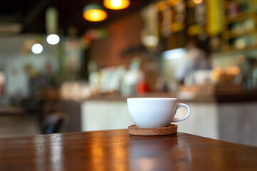 White hot coffee cup on table in coffee shop with blurred background
