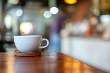 White hot coffee cup on table in coffee shop with blurred background