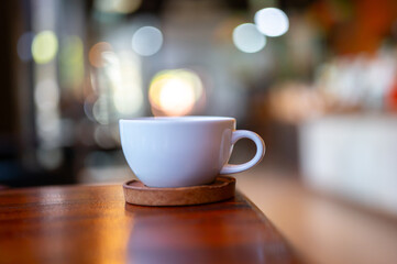 White hot coffee cup on table in coffee shop with blurred background