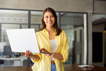 Smiling latin hispanic female manager, professional specialist working, browsing at laptop computer...