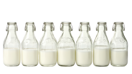 A collection of glass milk bottles, each filled with fresh, white milk, lined up against a clean white background.
