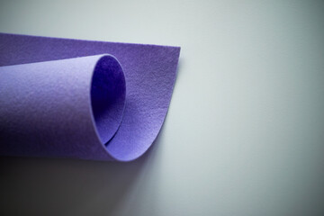 Purple roll of soft felt on a light background.Material for needlework.Synthetic felt that does not contain natural wool.