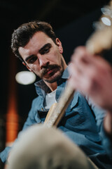 A musician intensely plays a guitar in a professional recording studio environment, focusing on the melody.