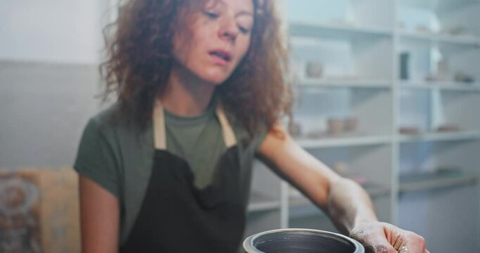 Crafting a unique pottery vase in a studio setting during a creative session with hands covered in clay