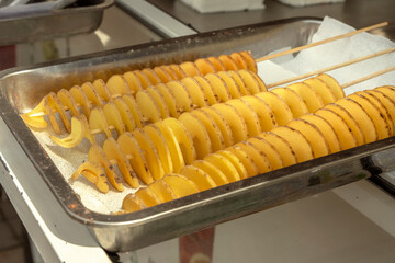 Raw tornado potato chips or spiral chips. Street food