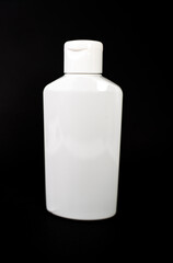 white shampoo bottle on a black background