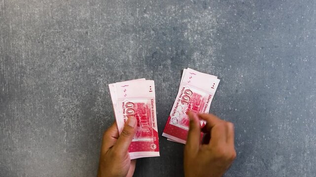Close up of businessman counts money in hands. Pakistan one hundred rupees new banknotes.