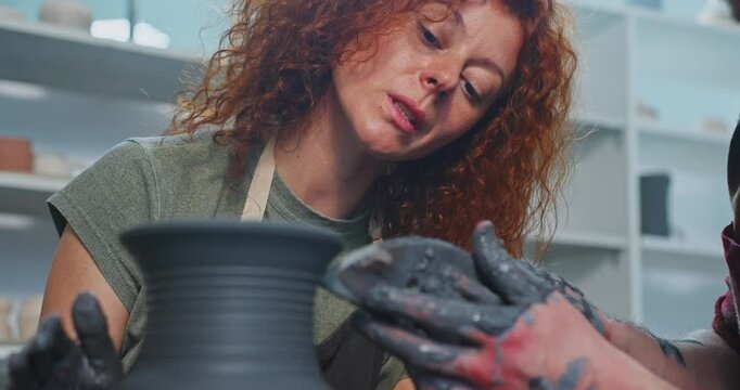 Exploring pottery crafting techniques at a workshop in a creative studio with an expert instructor guiding beginners