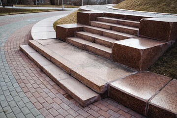 A beautiful set of stairs constructed from stone and bricks, elegantly placed on a wellmaintained sidewalk for pedestrians to use and enjoy while walking along their route