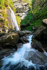 waterfall in the alps with cascade river flow in front long exposure