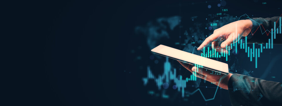 Businessperson using tablet with financial data and digital chart overlay on dark background symbolizing technology-driven business analysis..