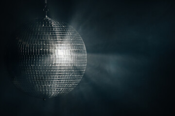 Disco mirror ball illuminates the background of a nightclub. A party is illuminated by a disco...
