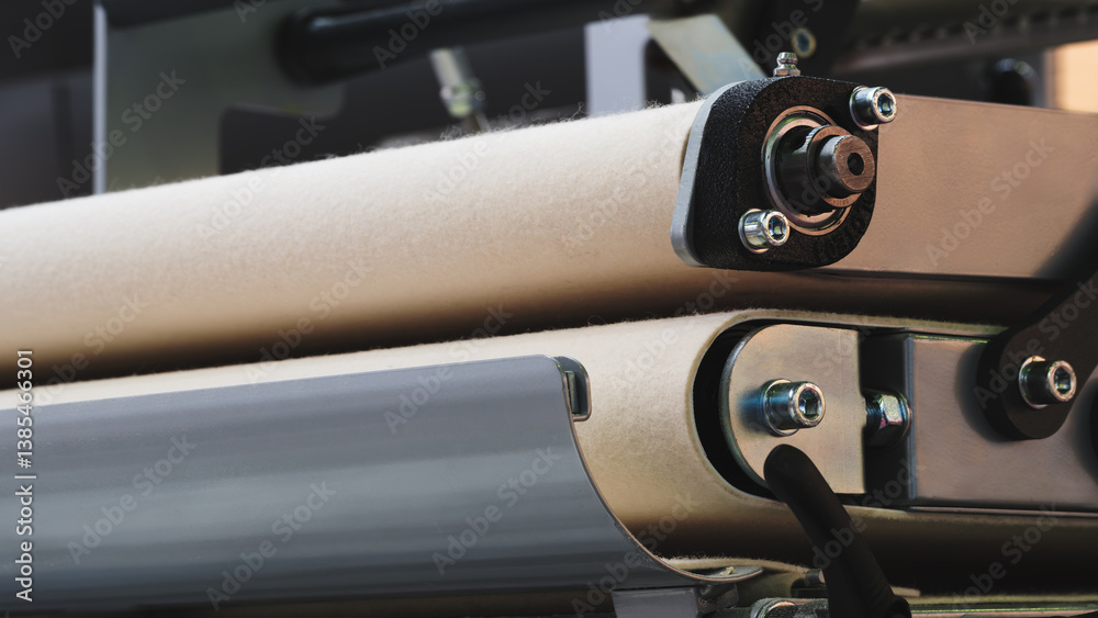 Poster a machine with a belt made of a material that is not visible. the belt is attached to a metal machin