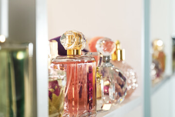 Different bottles of luxury perfume on shelf in store, closeup