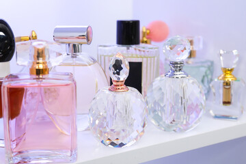 Different bottles of luxury perfume on shelf in store, closeup