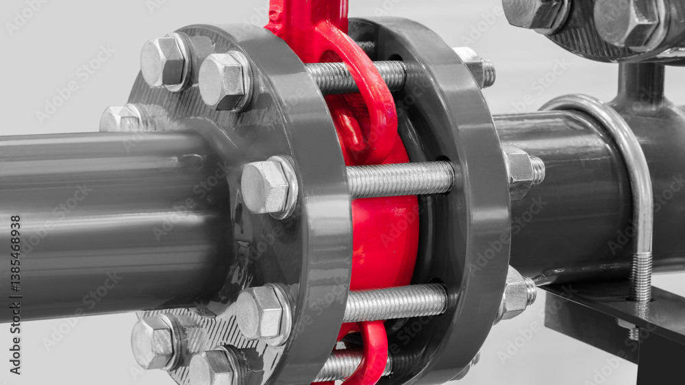 Poster A red and silver pipe with a red cap is attached to a silver pipe. The red cap is secured with several bolts and nuts