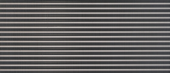 Close-up of a black metal surface with many small lines as a metallic industrial texture background. The lines are very close to each other and the surface is very shiny