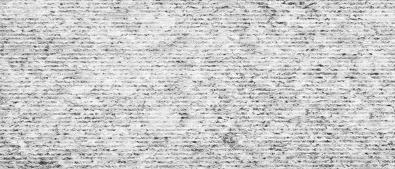 A gray and white striped wall with a lot of texture. The wall is very rough and has a lot of lines