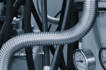 A long, silver pipe with a gauge on it. The pipe is surrounded by other pipes and gauges