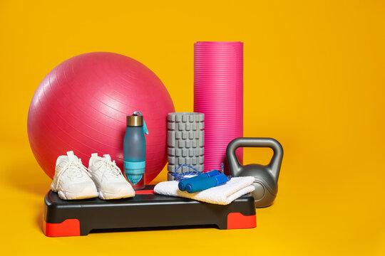 Many different fitness equipment on orange background