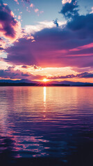 Fototapeta premium Serene Sunset Over Lake: The sun dips below the horizon, casting a warm golden light over a tranquil lake, with clouds painted in hues of pink, purple, and orange.