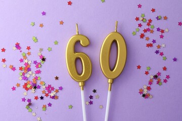 60th birthday. Number shaped candles and confetti on violet background, flat lay