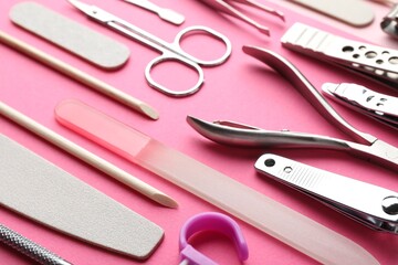 Set of different manicure tools on bright pink background, closeup