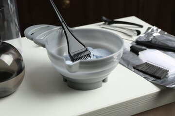 Bleaching powder and hairdresser's tools on white table in salon