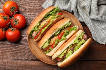 Tasty hot dogs with vegetables on wooden table, flat lay